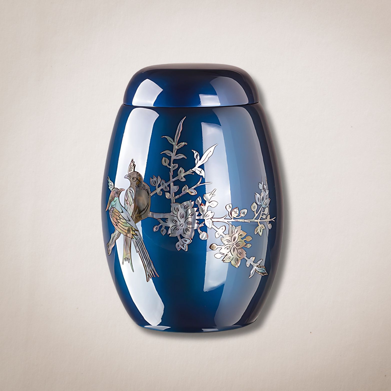 Een blauwe vaas met een vogel en bloemen erop