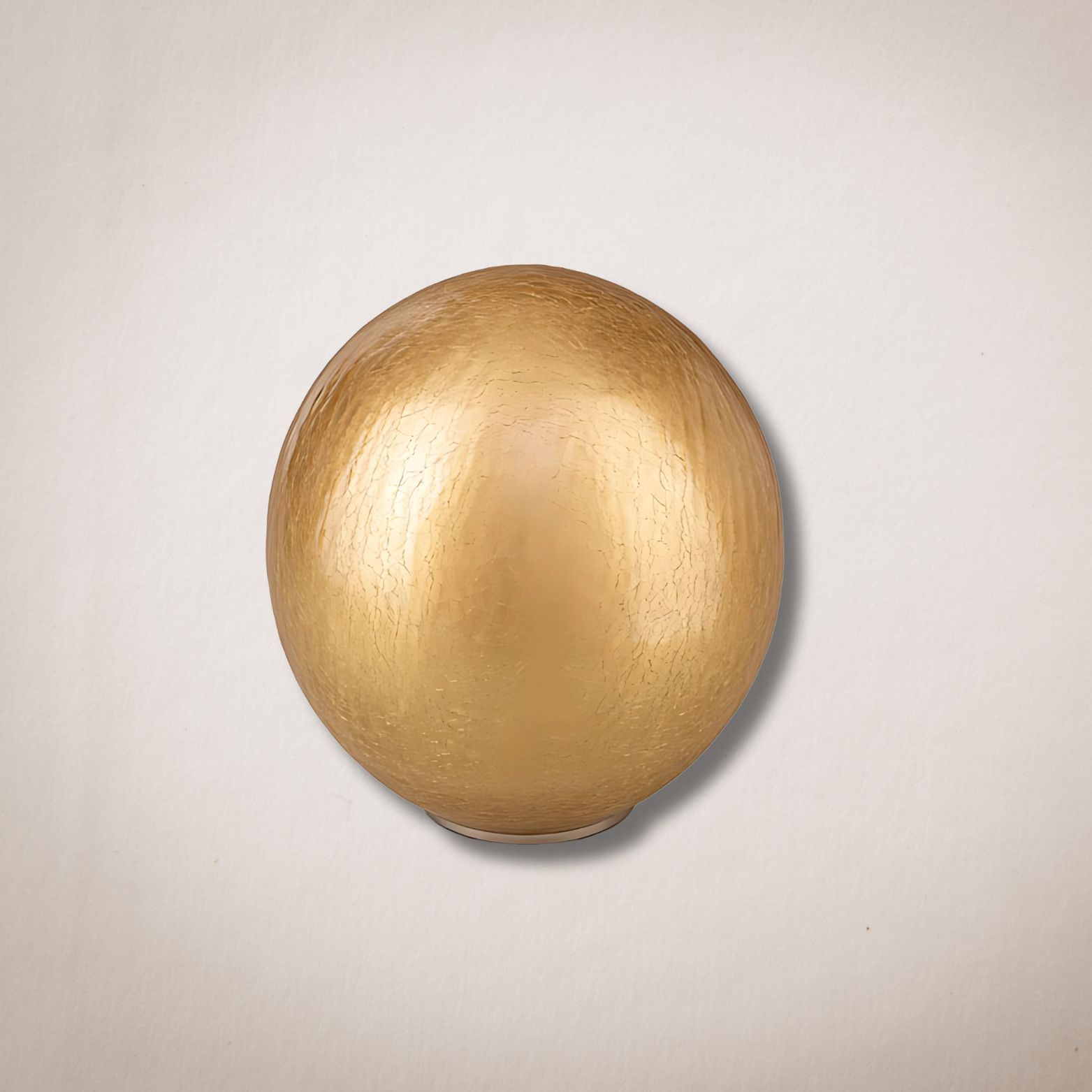 Een gouden bal ligt op een wit oppervlak.