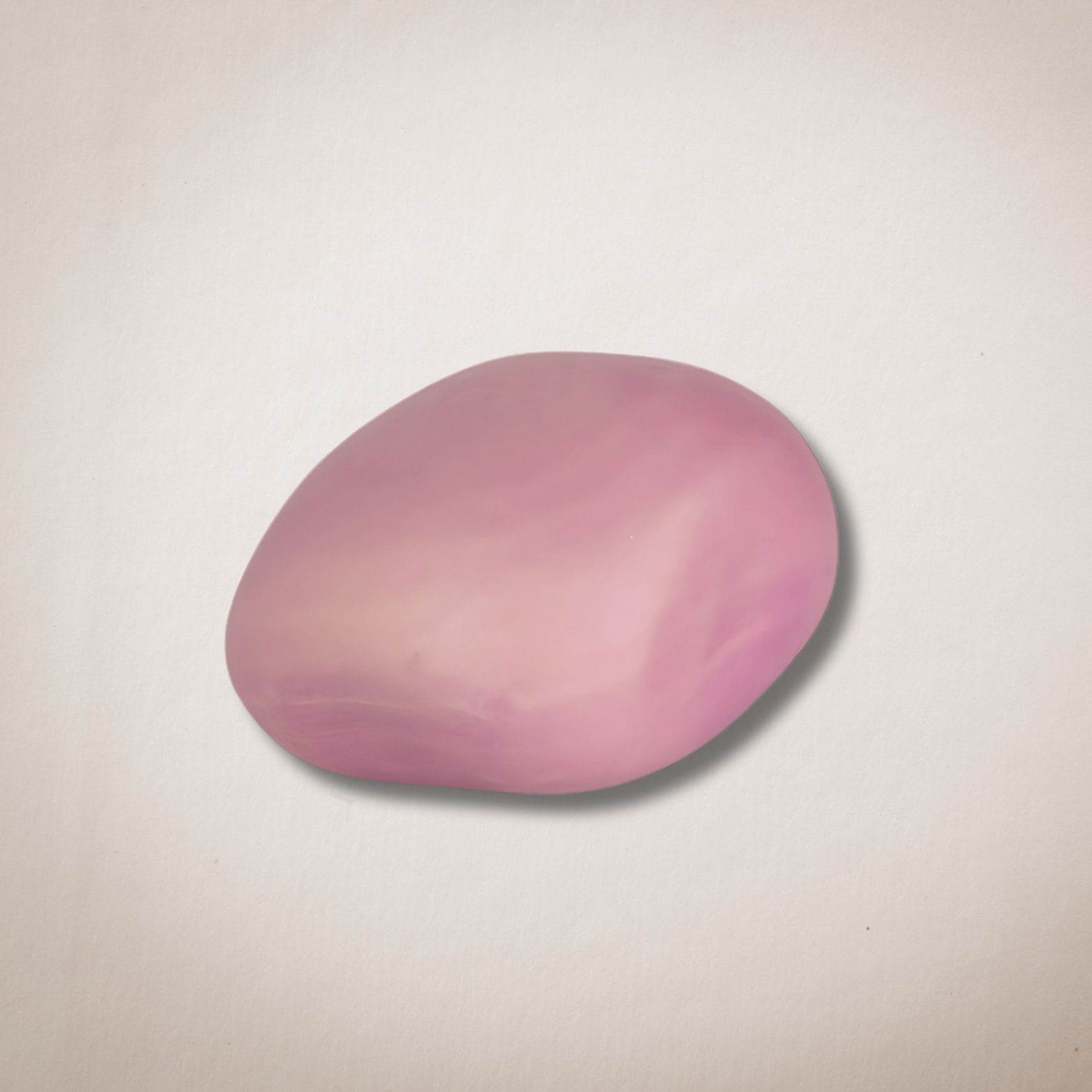 Een roze stuk zeep ligt op een wit oppervlak.