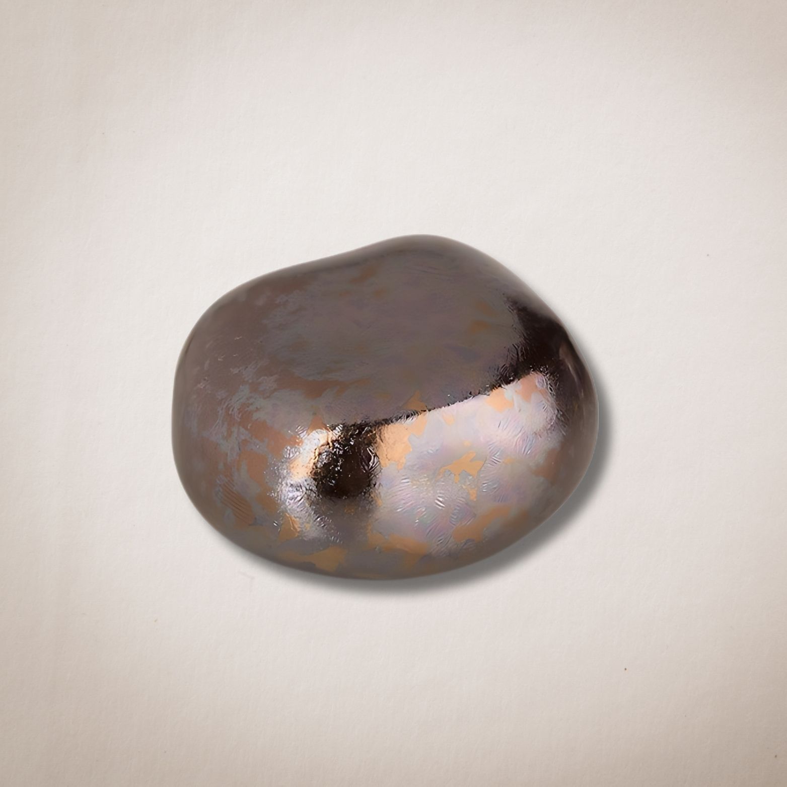 Een klein metalen voorwerp ligt op een wit oppervlak.