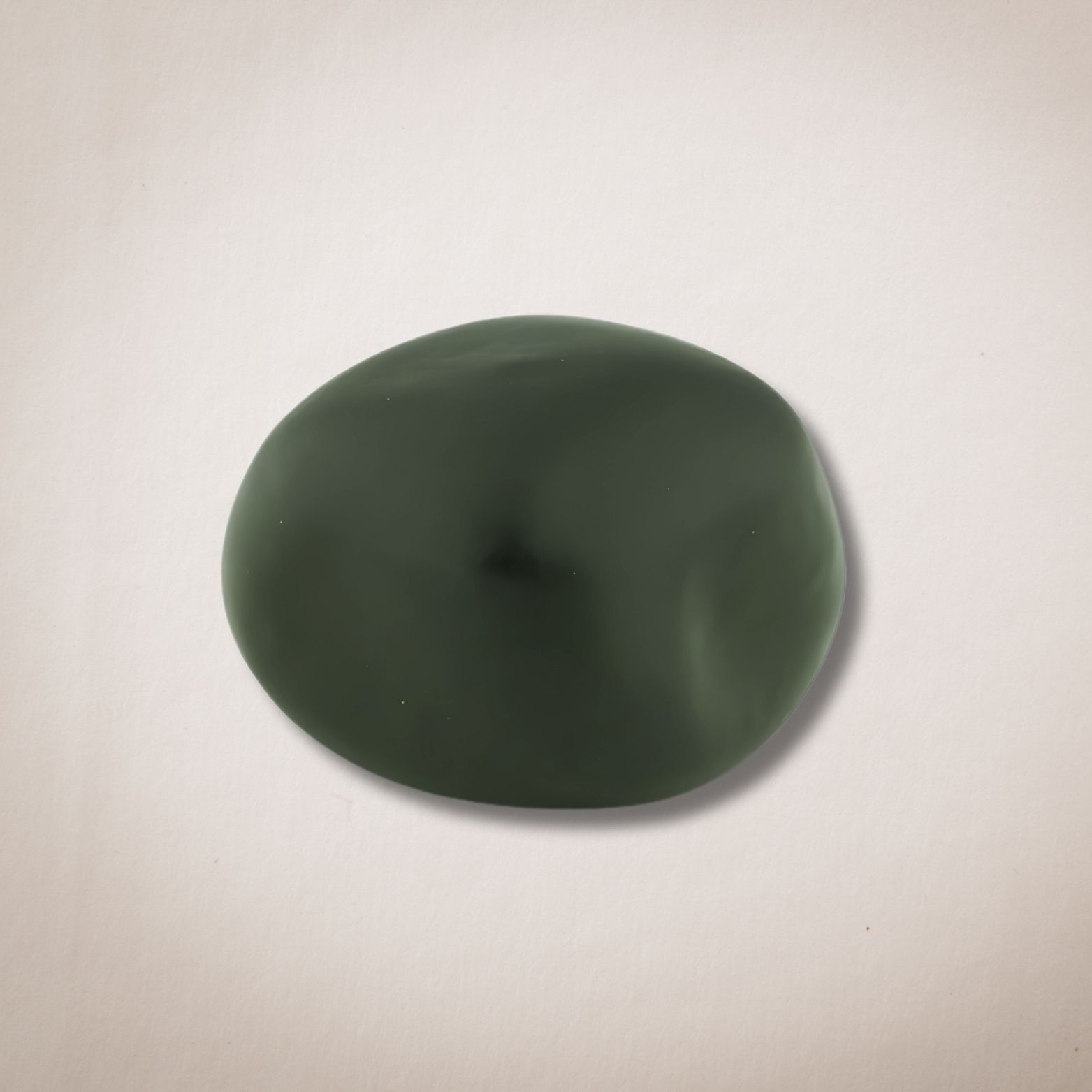 Een groene steen ligt op een wit oppervlak.