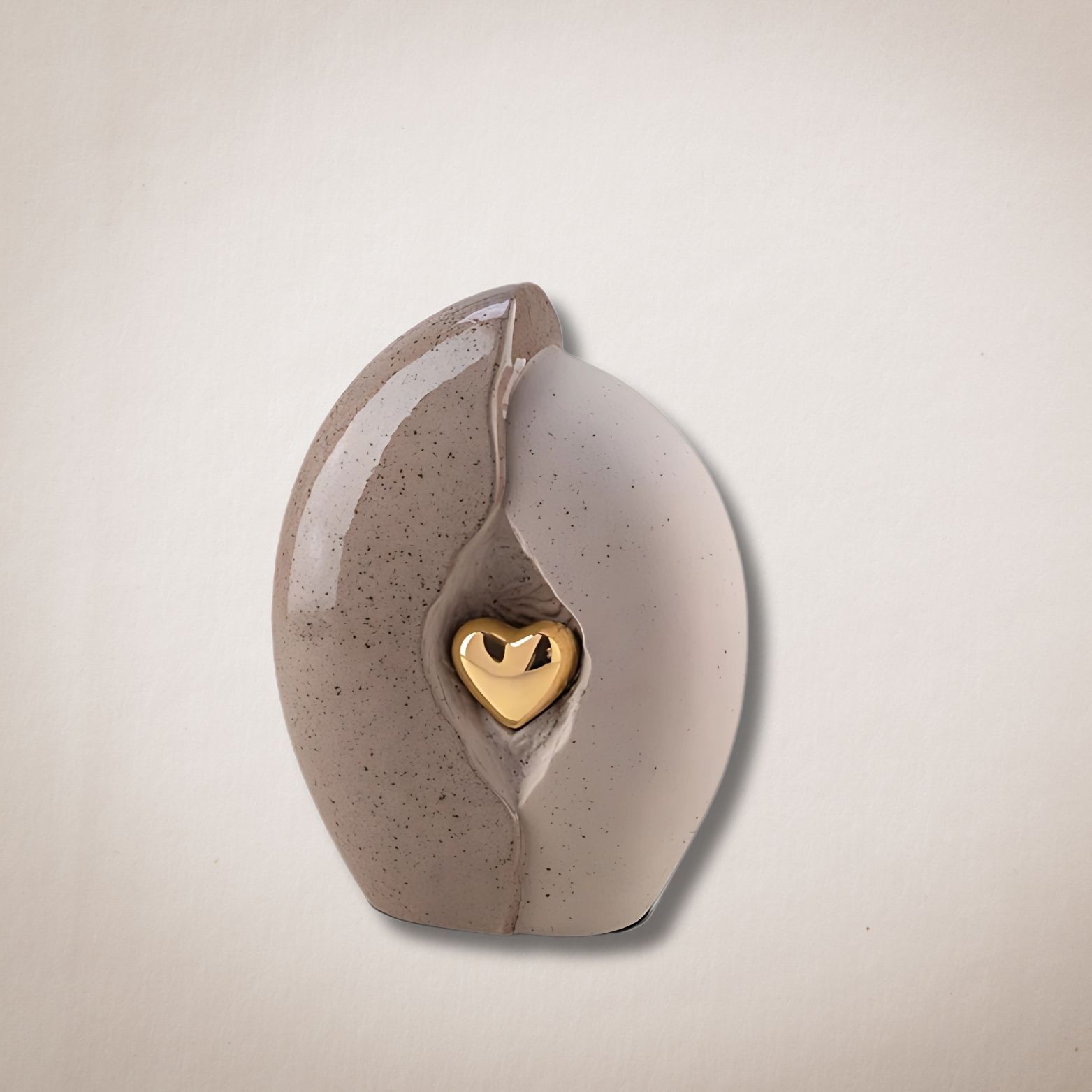 Een keramische urn met daarin een gouden hart