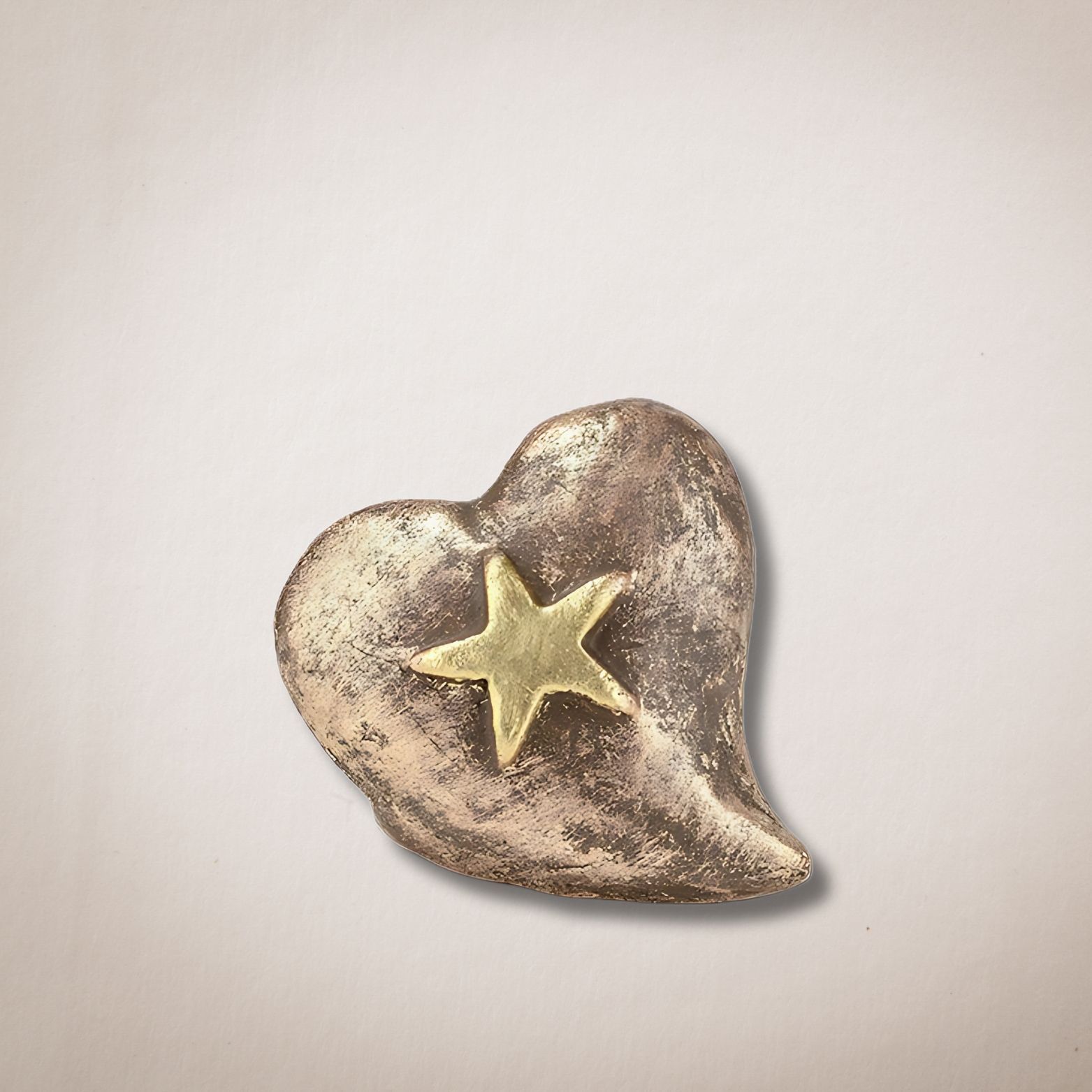 Een bronzen hart met een gouden ster in het midden