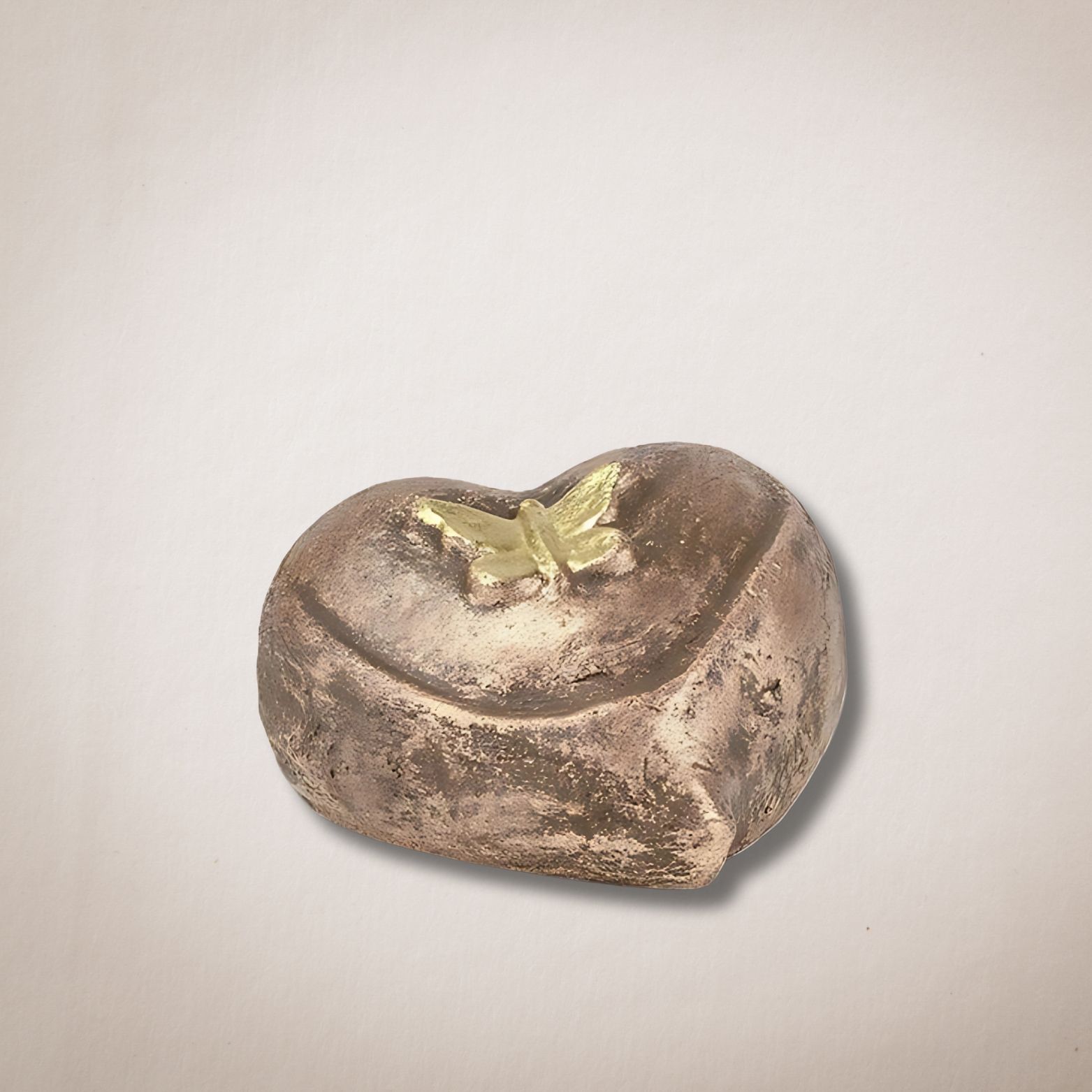 Een bronzen hart met daarop een vlinder