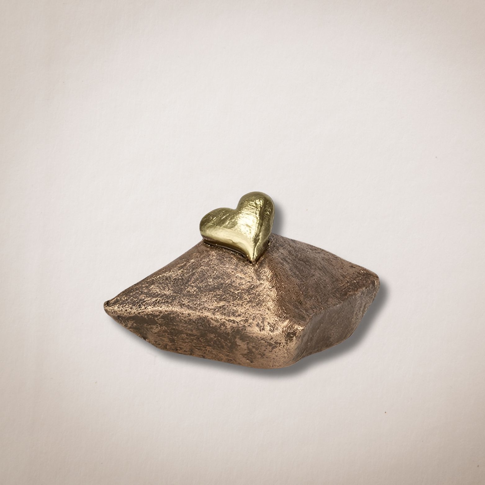 Een klein bronzen beeldje met een gouden hart erop