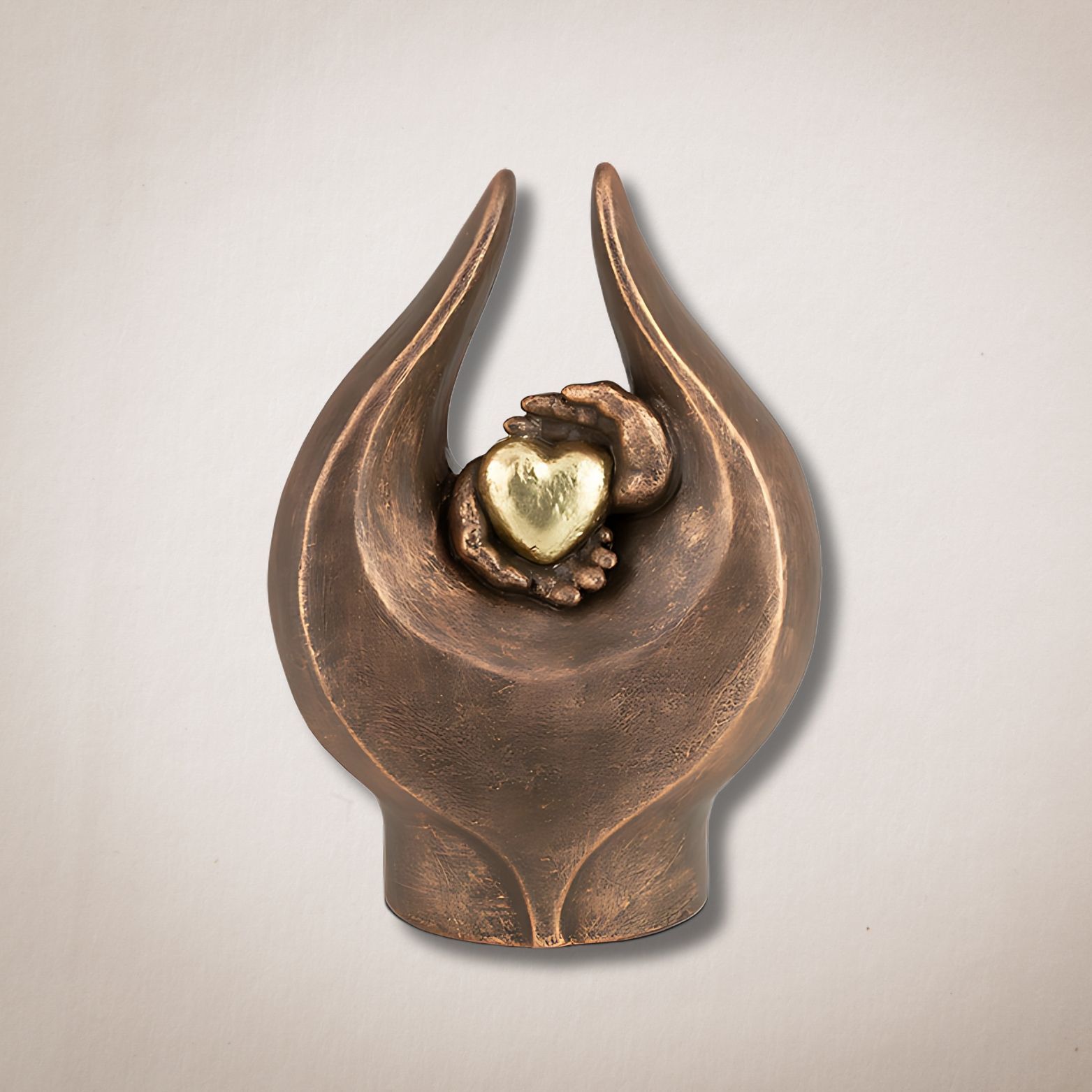 Een bronzen beeld van twee handen die een hart vasthouden