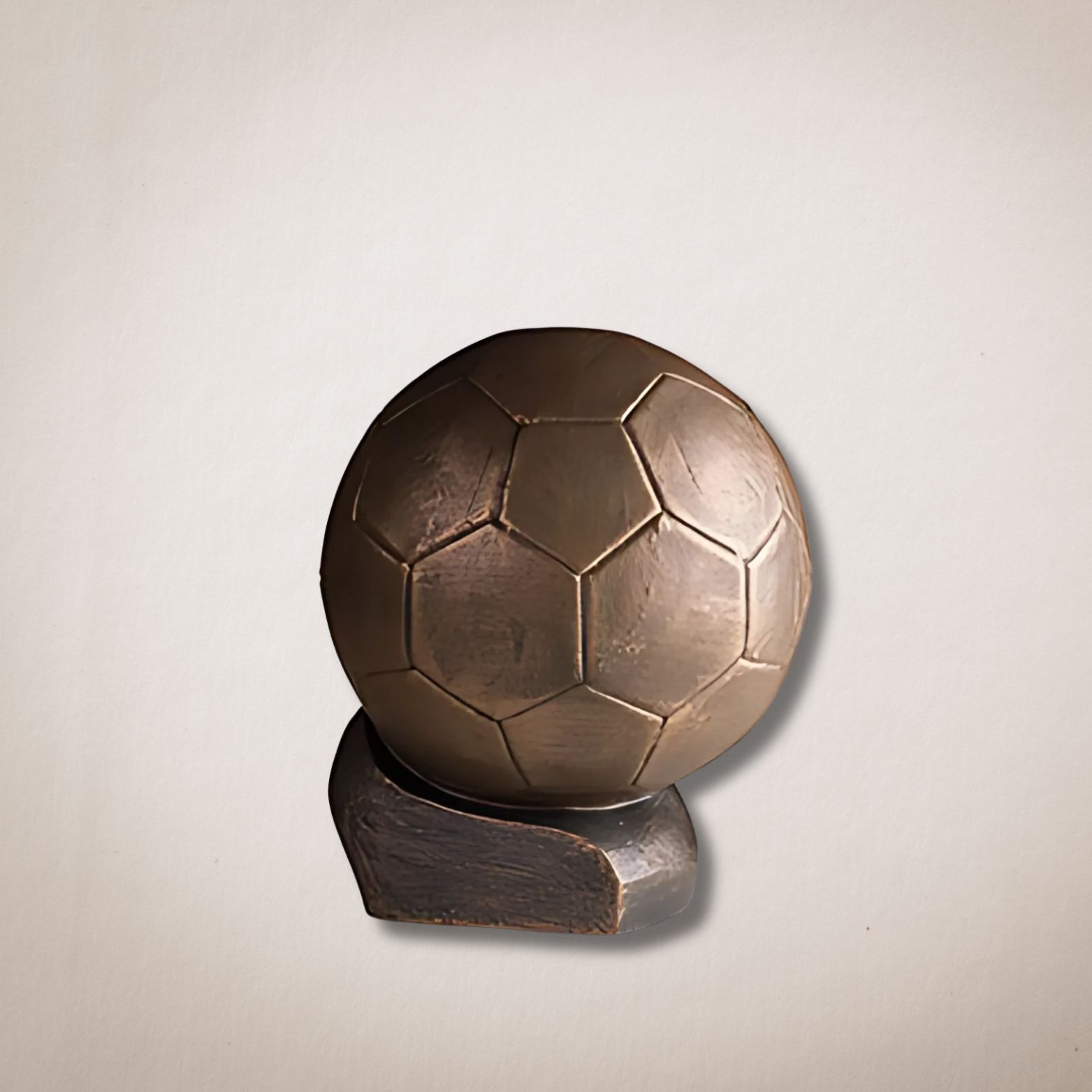 Een bronzen voetbal staat op een houten standaard