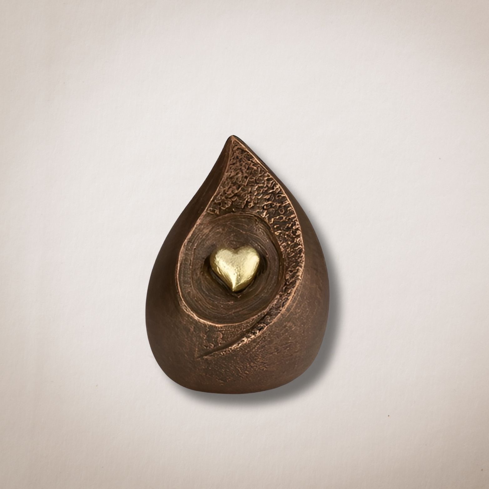 Een bronzen traan met daarin een gouden hart