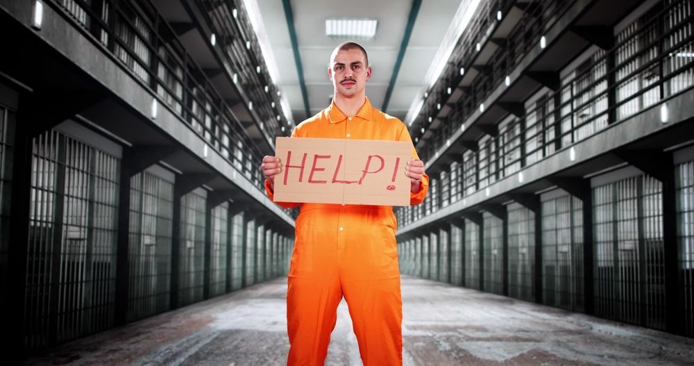 Man in orange prison jumpsuit holding