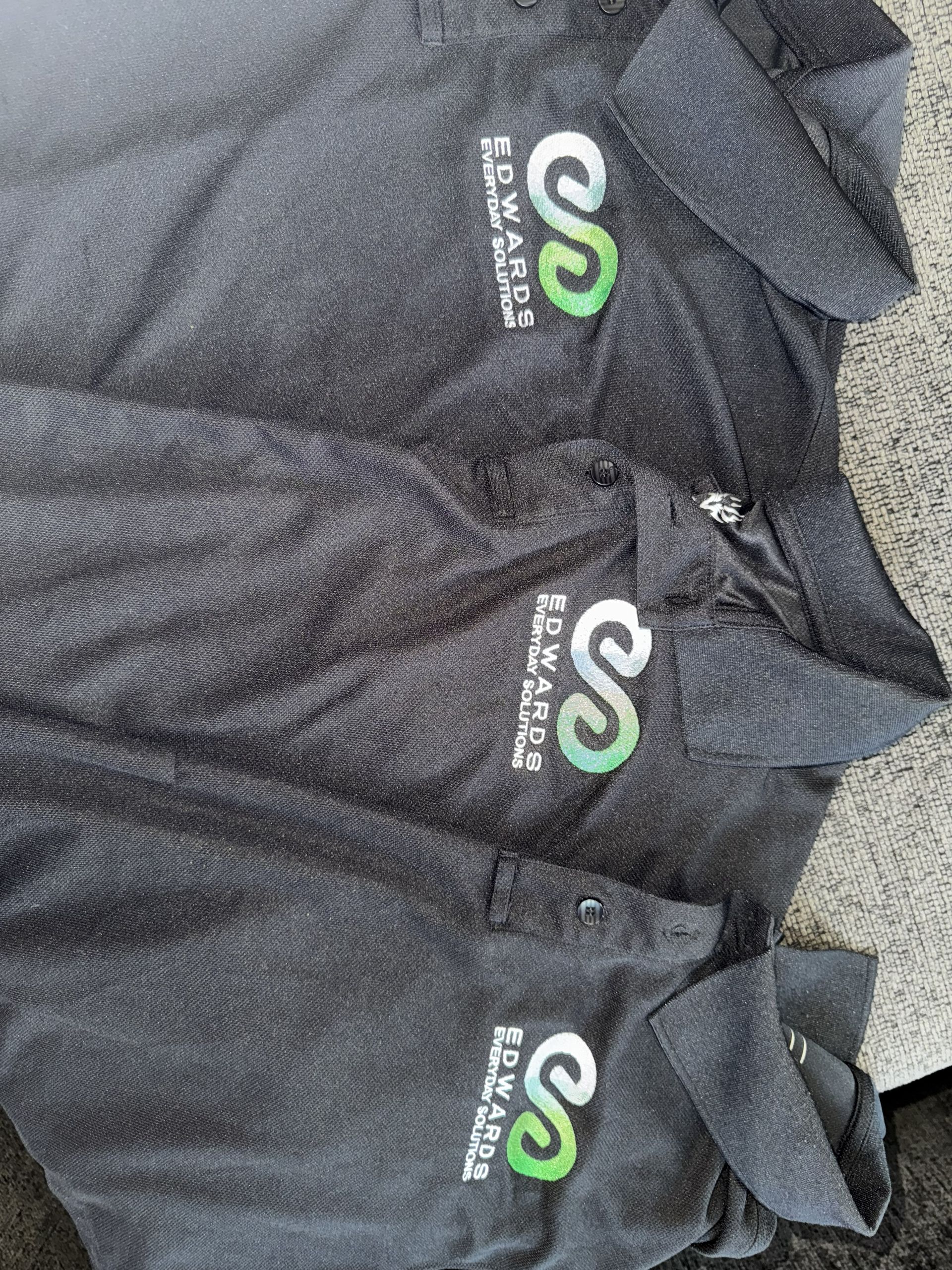 Three dark gray polo shirts with a green and white 
