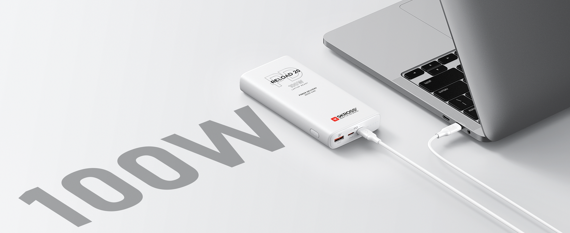 A power bank is plugged into a laptop on a table.