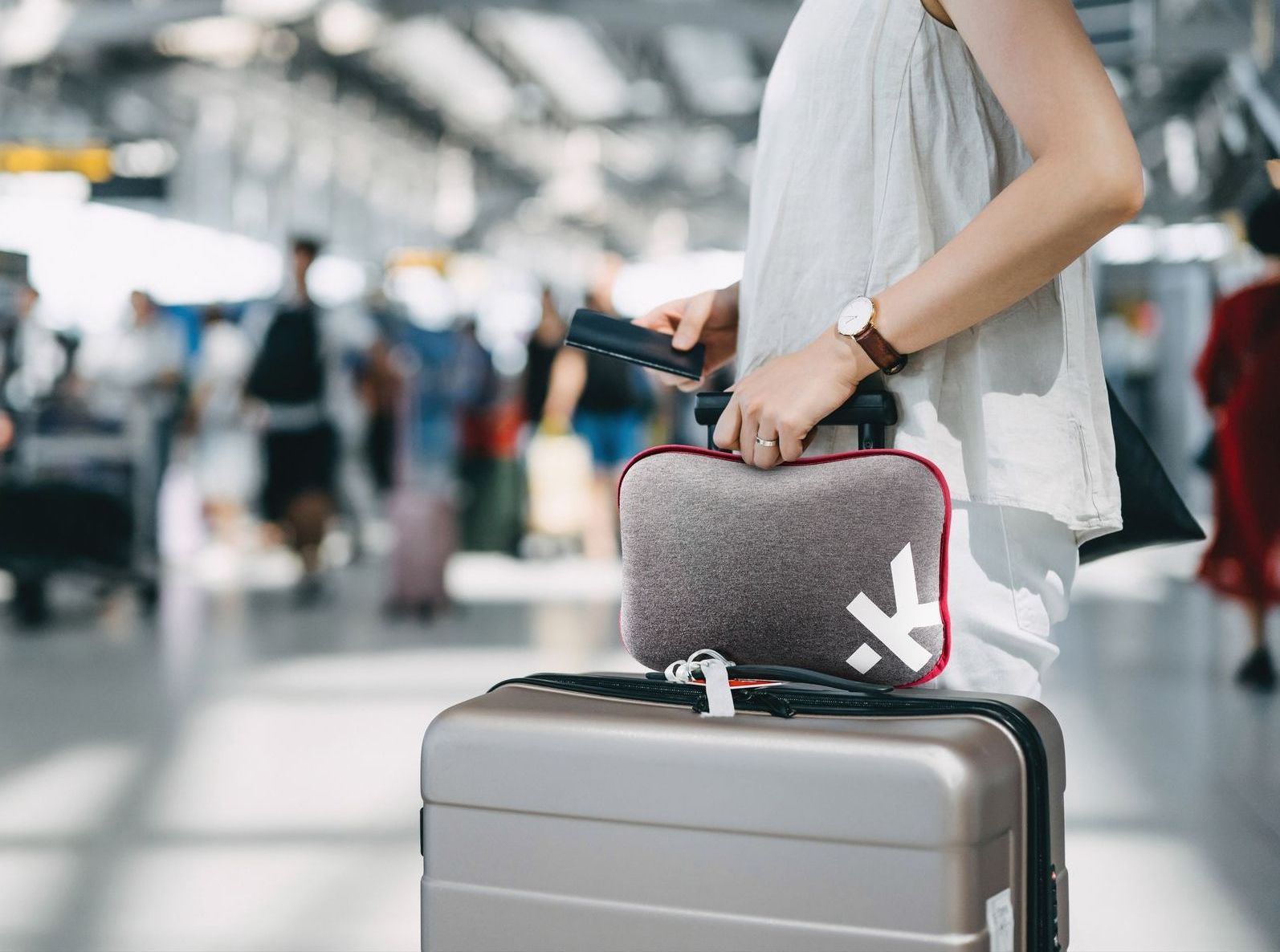 Grey Skross travel pillow on a suitcase in an airport