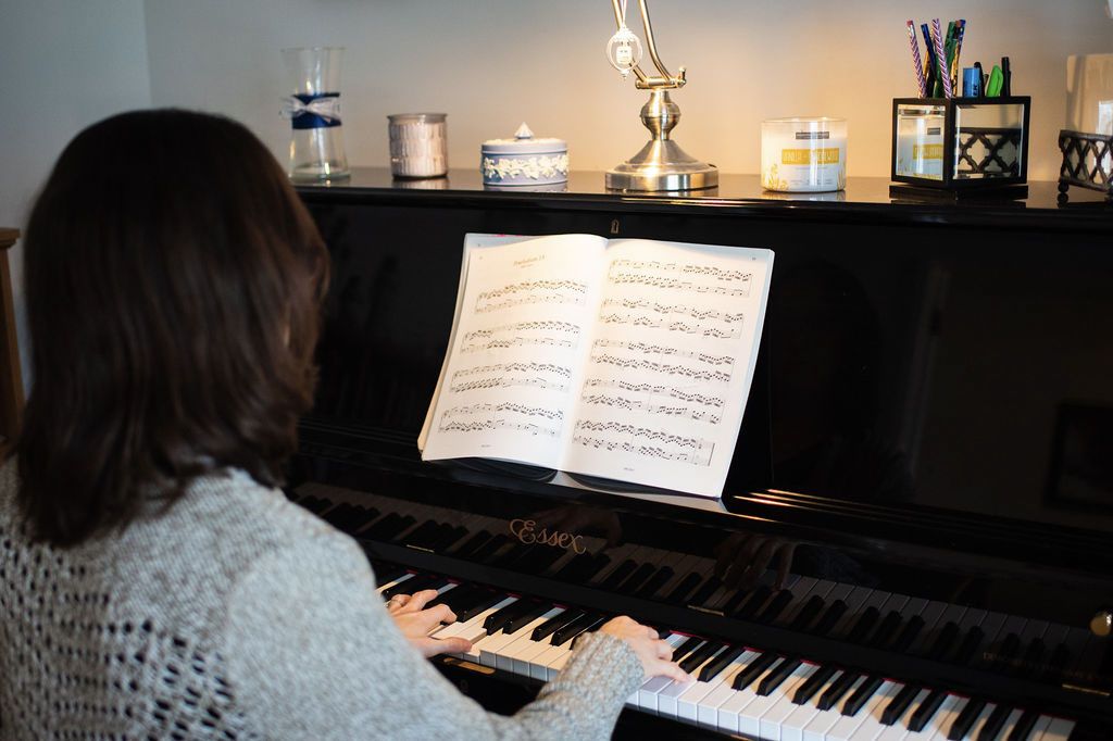 Black and white image of Miss Emma next to her piano