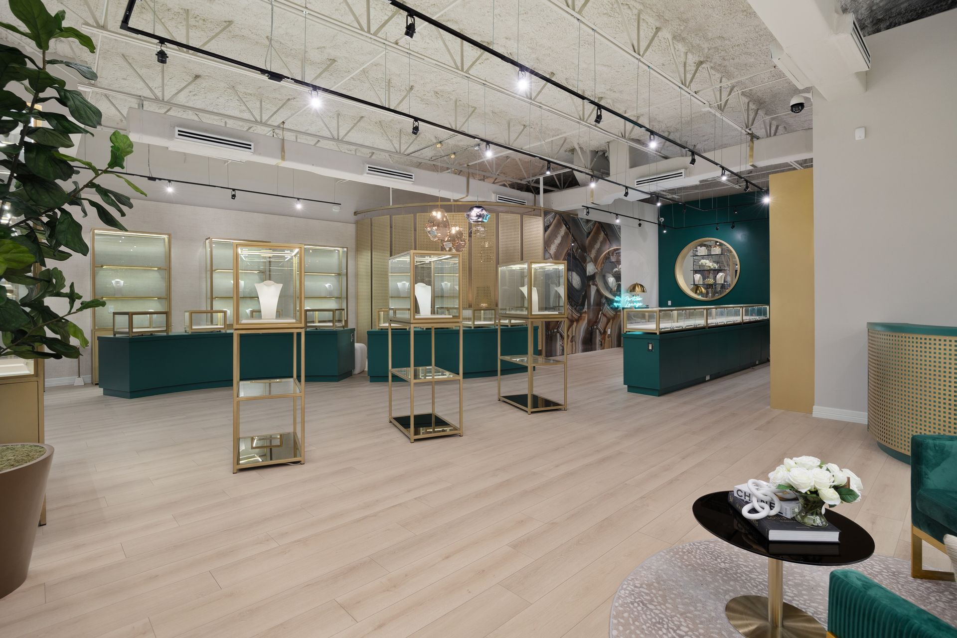 Modern retail interior with glass display cases, teal walls, and light wood flooring