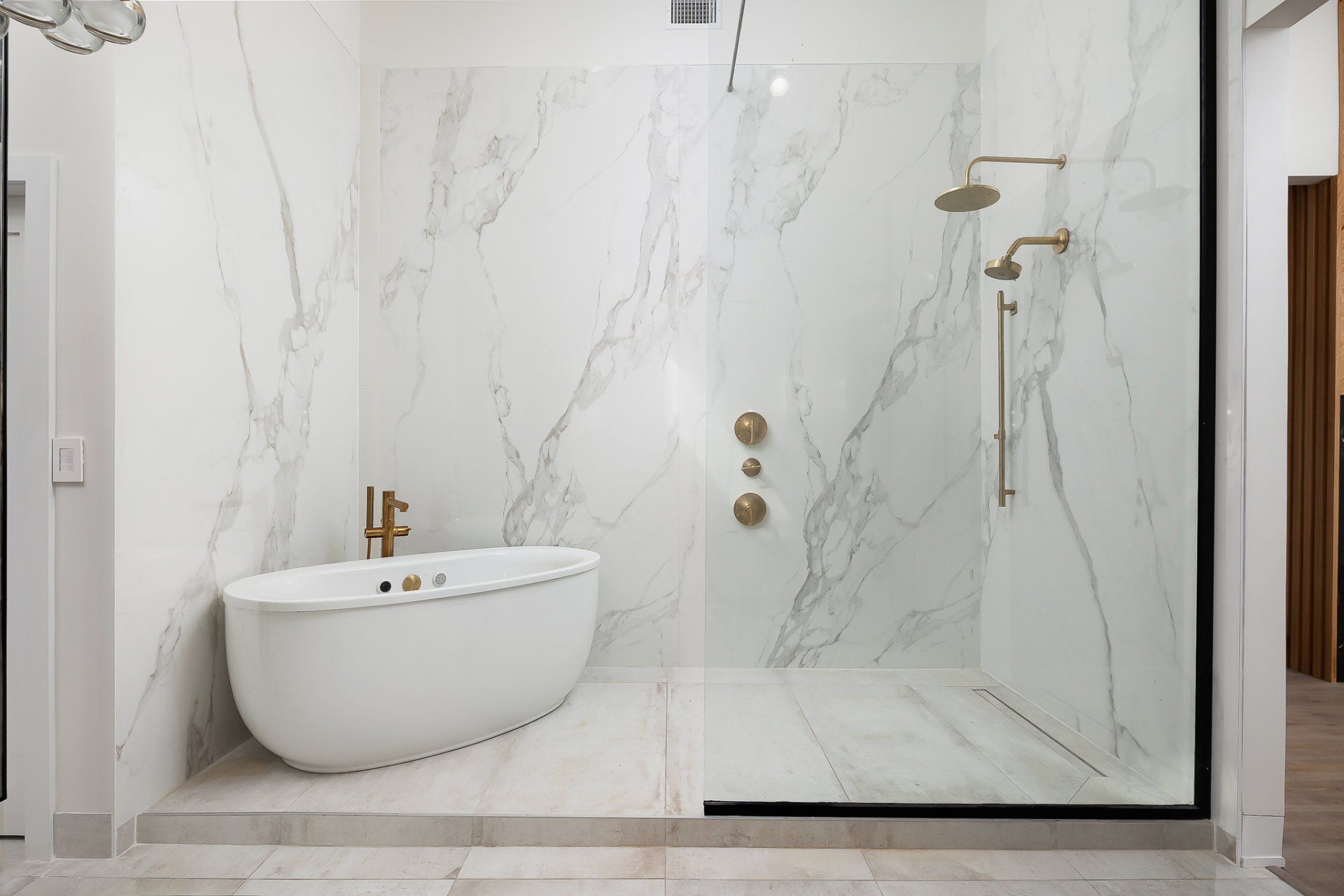 Modern marble bathroom with a freestanding tub and glass shower enclosure