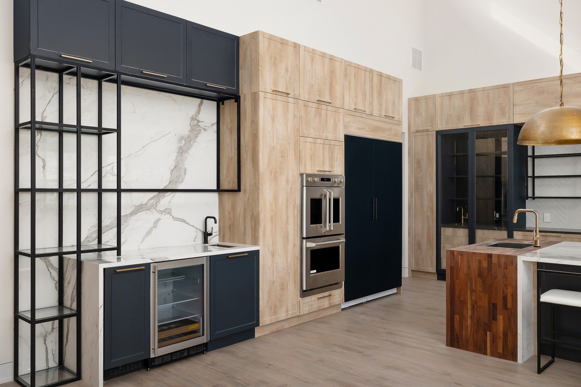 Modern kitchen with wood and black cabinetry, marble backsplash, and stainless steel appliances