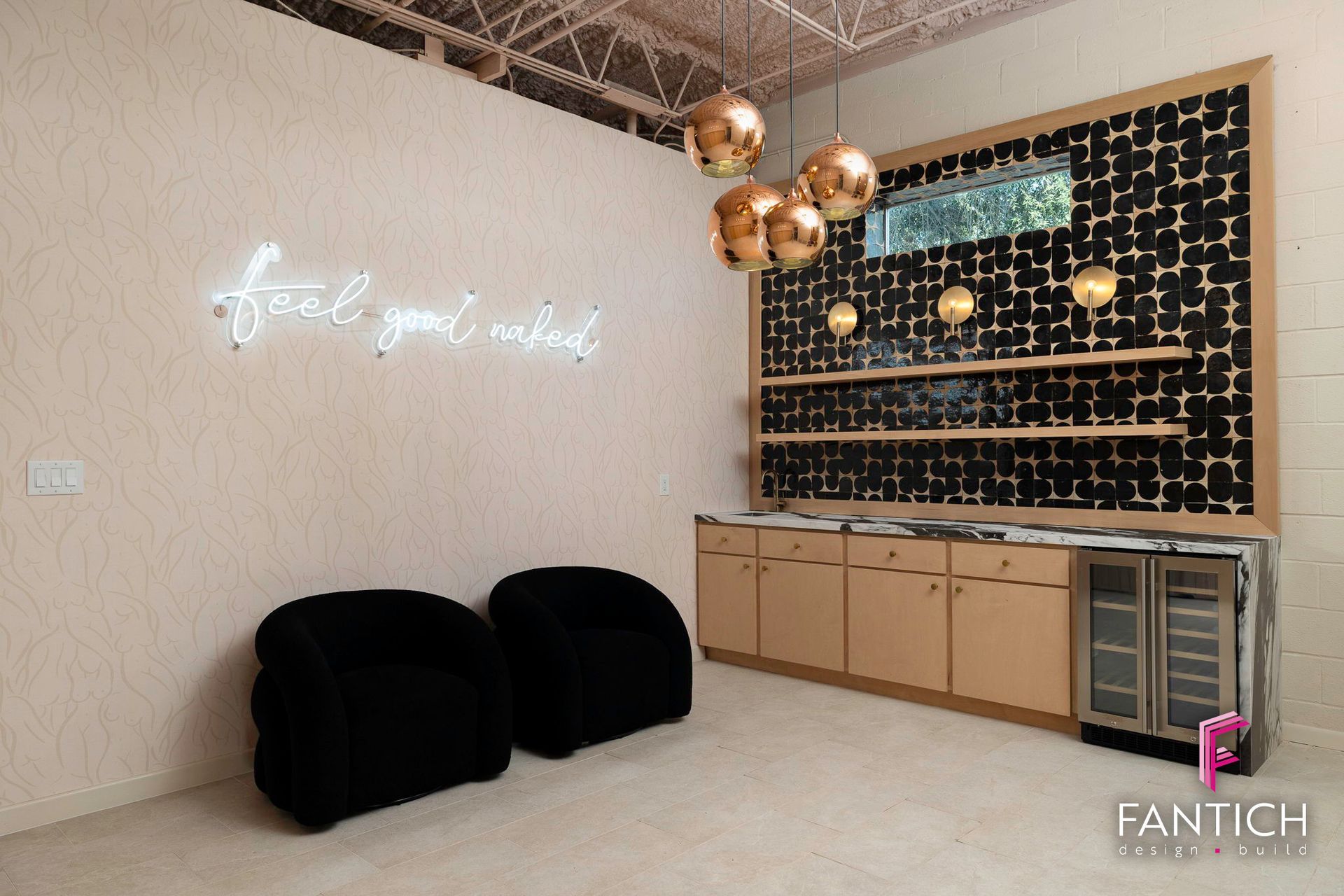 Modern salon interior with black chairs, beige walls, gold decor, and a patterned display wall