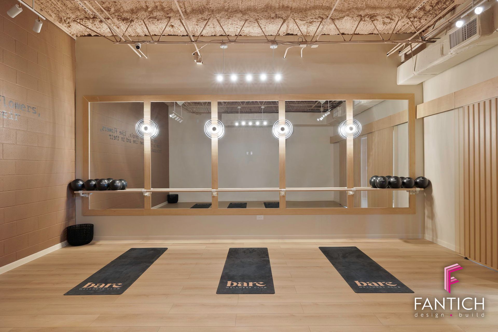 Modern shooting range with target stations, floor mats, and bright overhead lights in a wooden-walled room