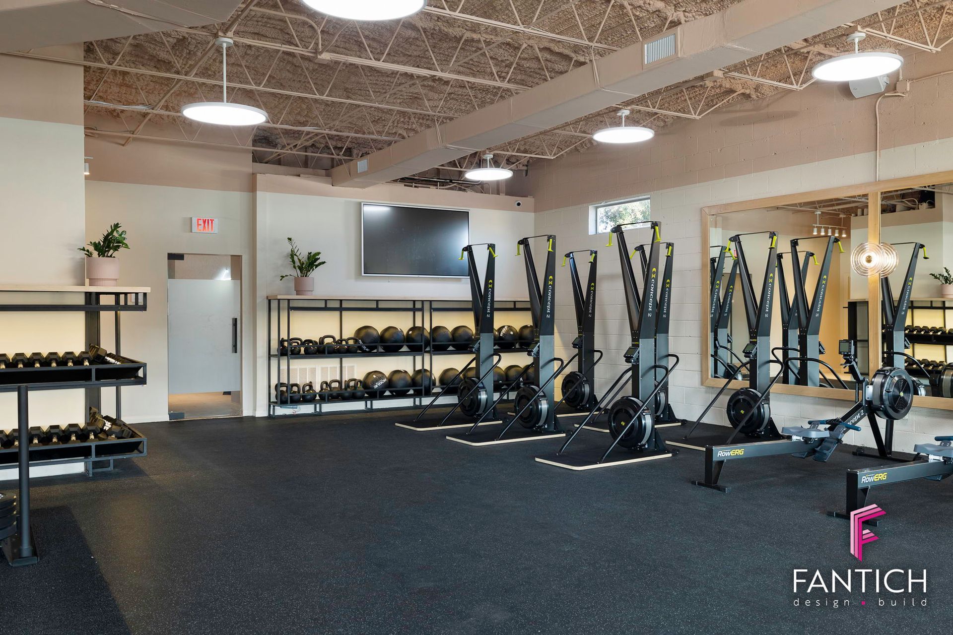 Modern gym with cardio machines, dumbbells, and black equipment on a carpeted floor