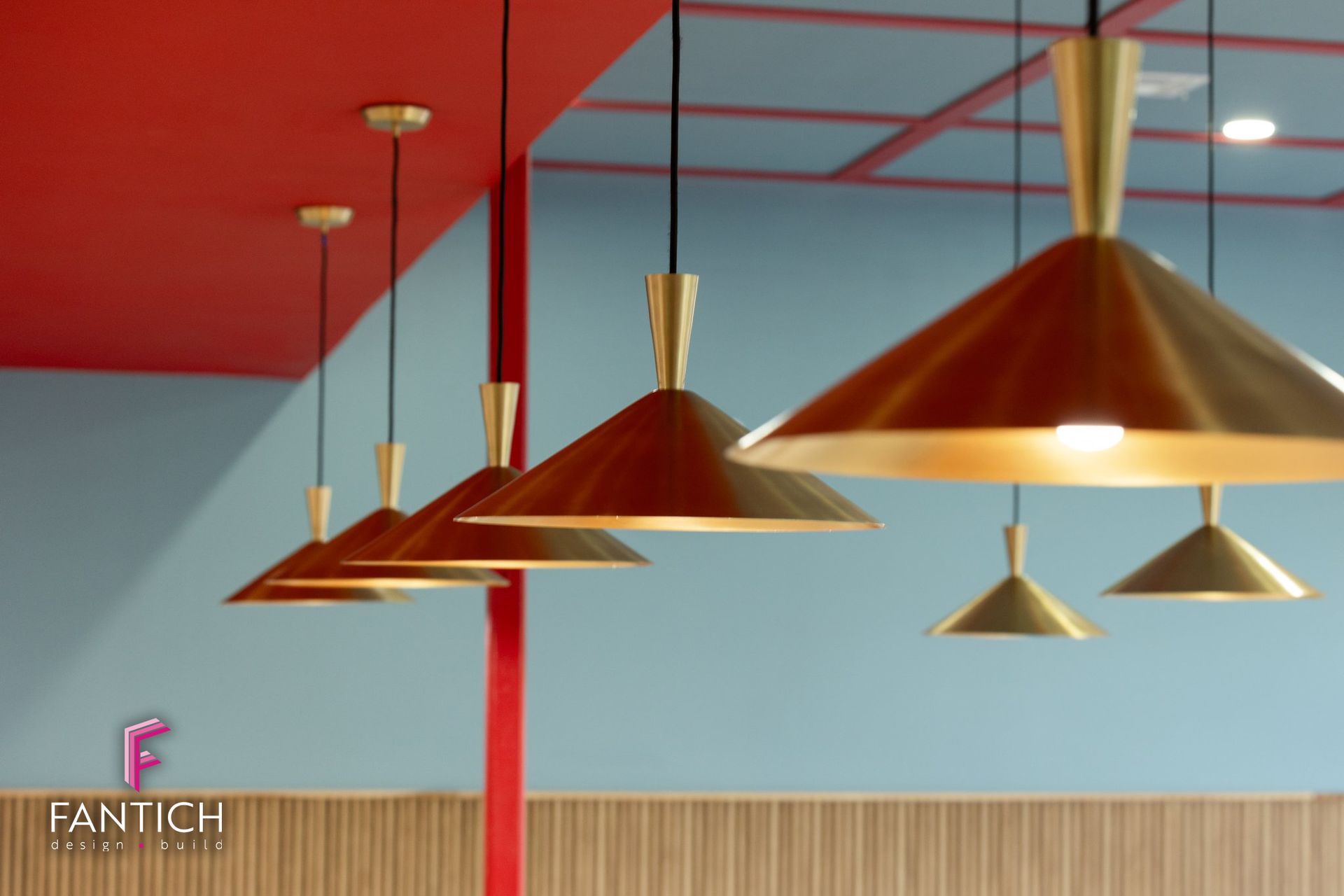 Modern interior with copper pendant lights, red ceiling, pale blue walls, and wooden wall paneling