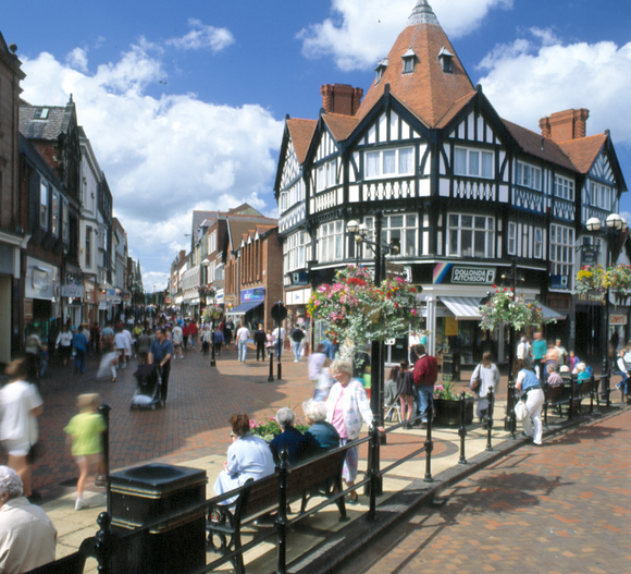 A cobblestone street in a city with a lot of buildings on both sides.