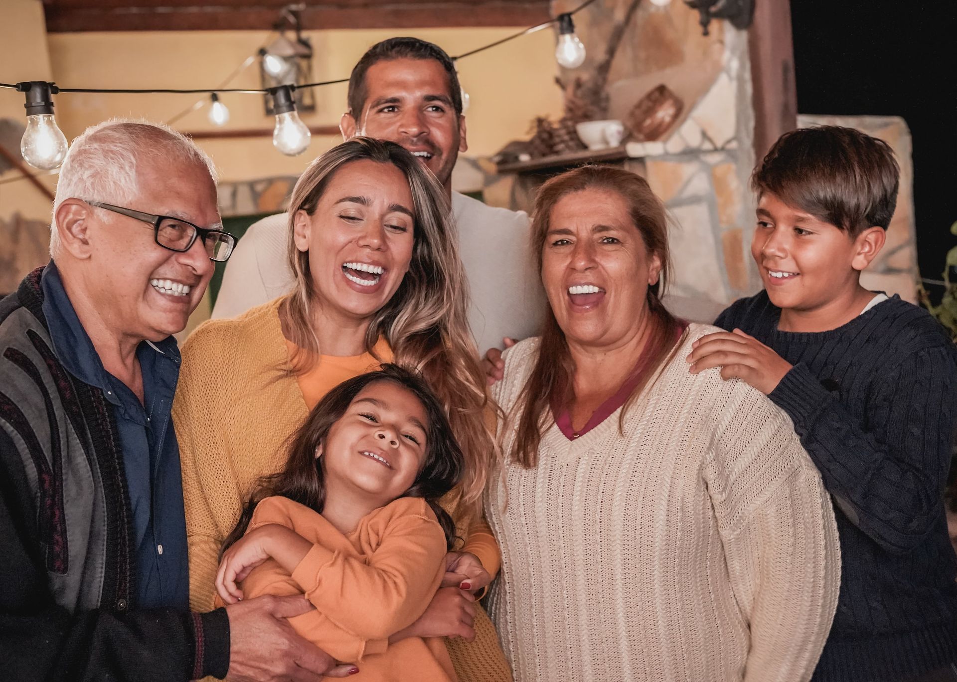 A large family is posing for a picture together and smiling.