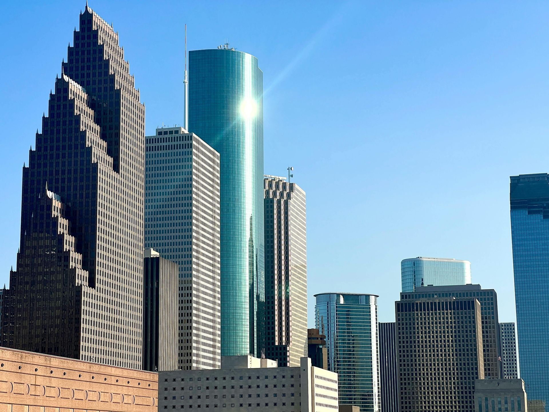 A city skyline with the sun shining through the buildings