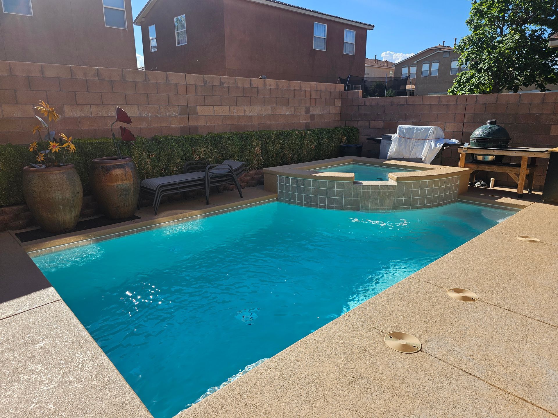 Bright blue winding pool or water feature surrounded by rocks and lush greenery outdoors