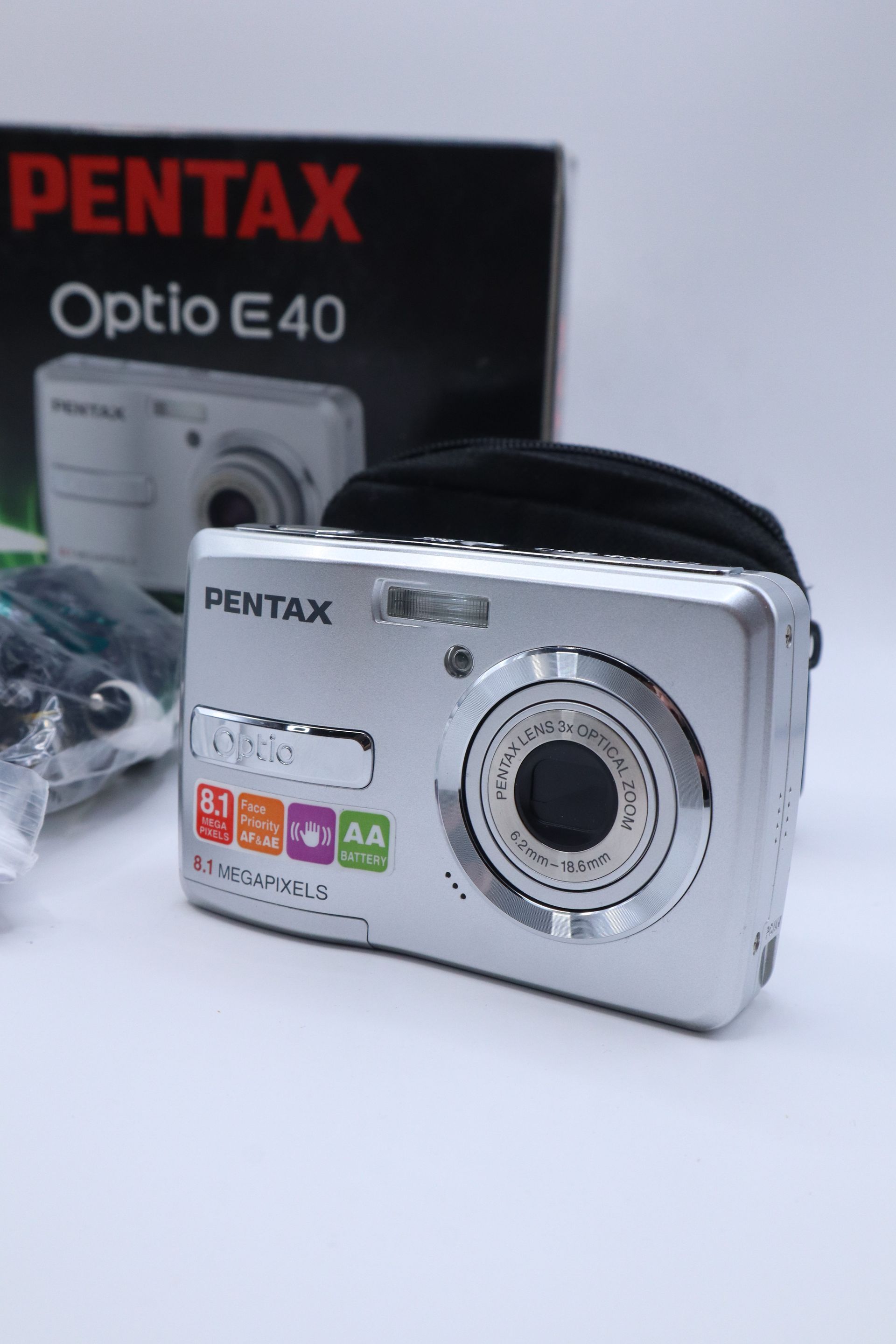 Pentax Optio E40 camera box with camera, battery charger, CD, cable, and case on a white surface