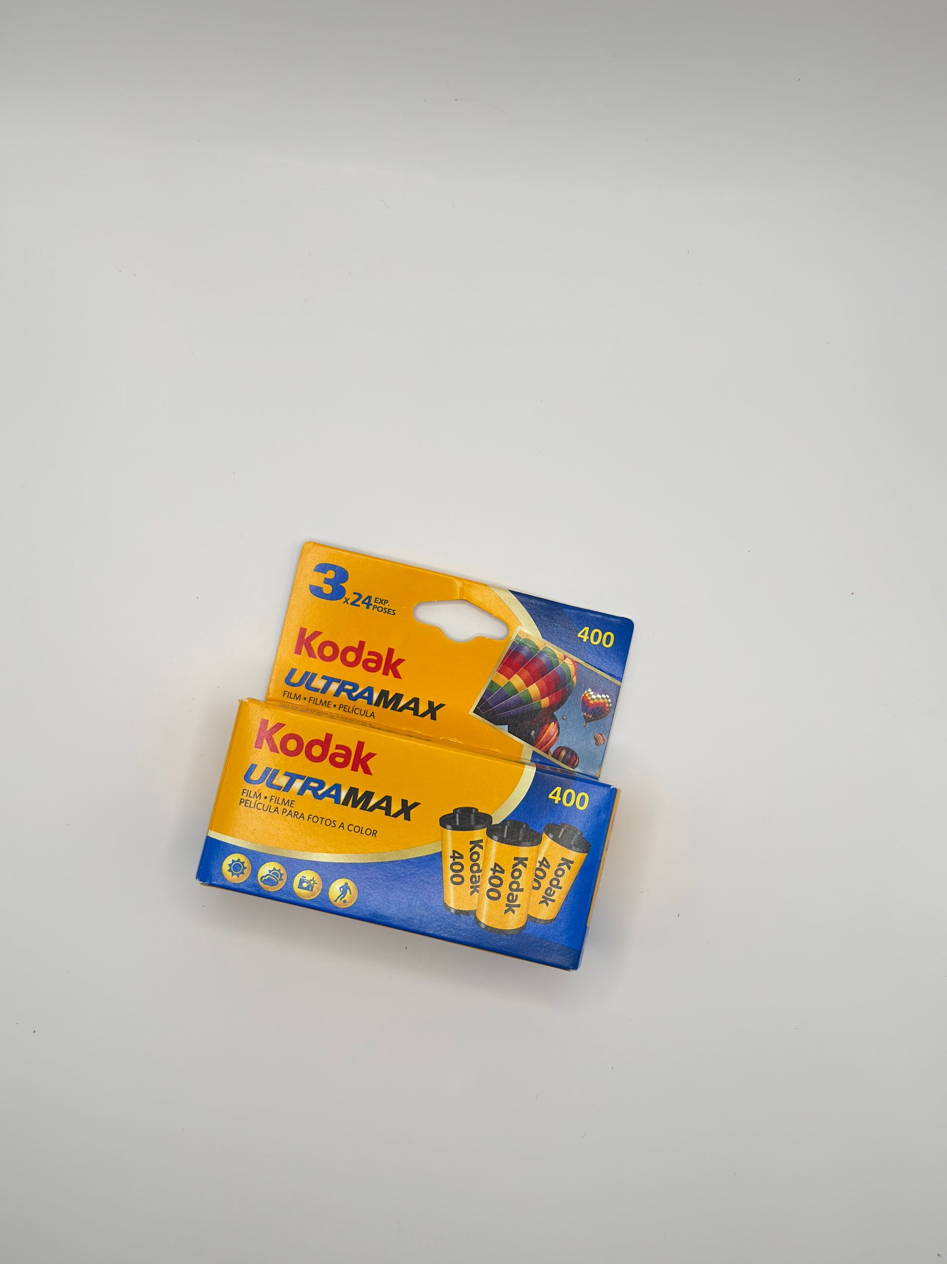Two Kodak disposable camera boxes, blue and yellow, on a white surface.