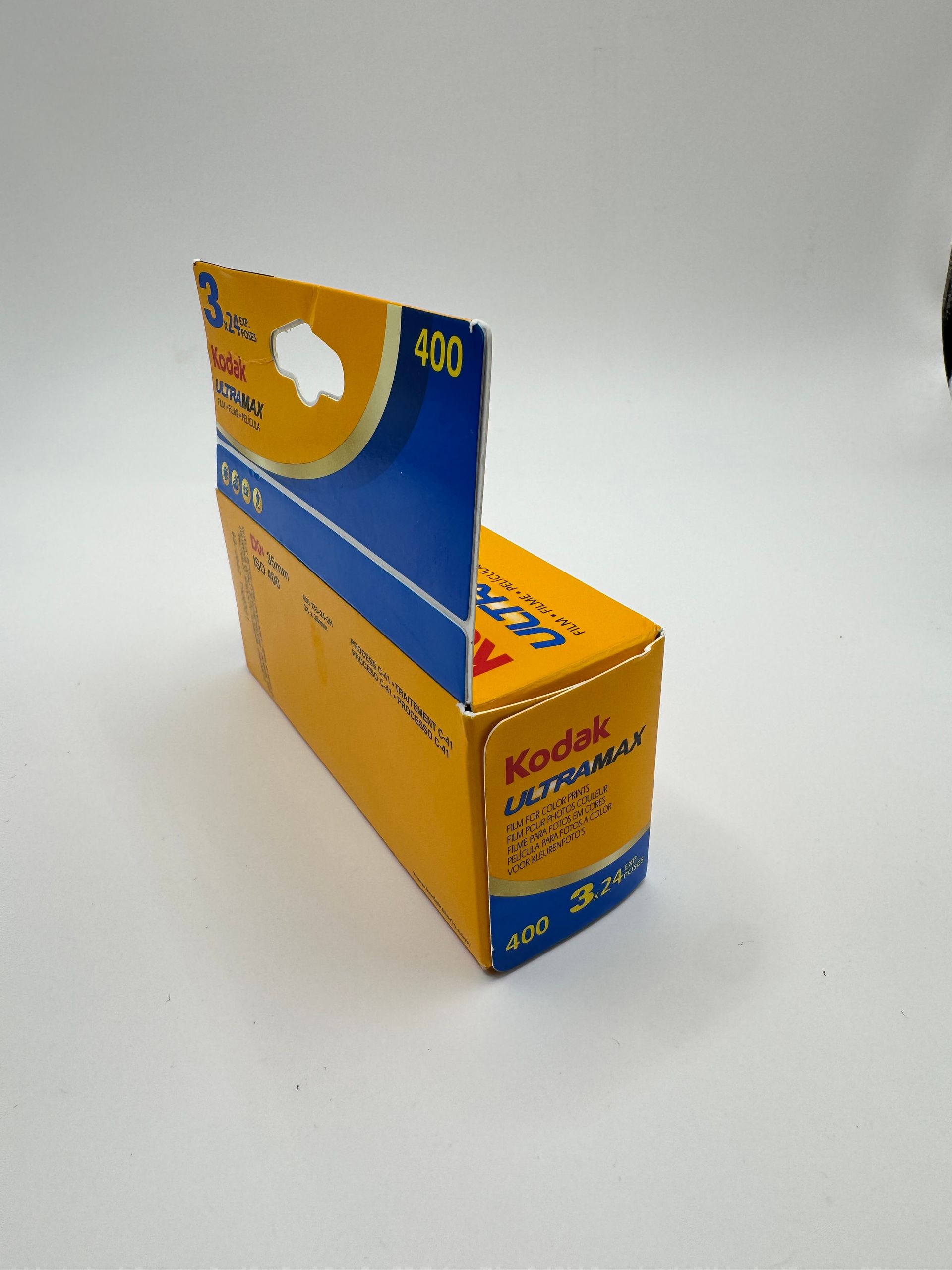 Two Kodak disposable camera boxes, blue and yellow, on a white surface.