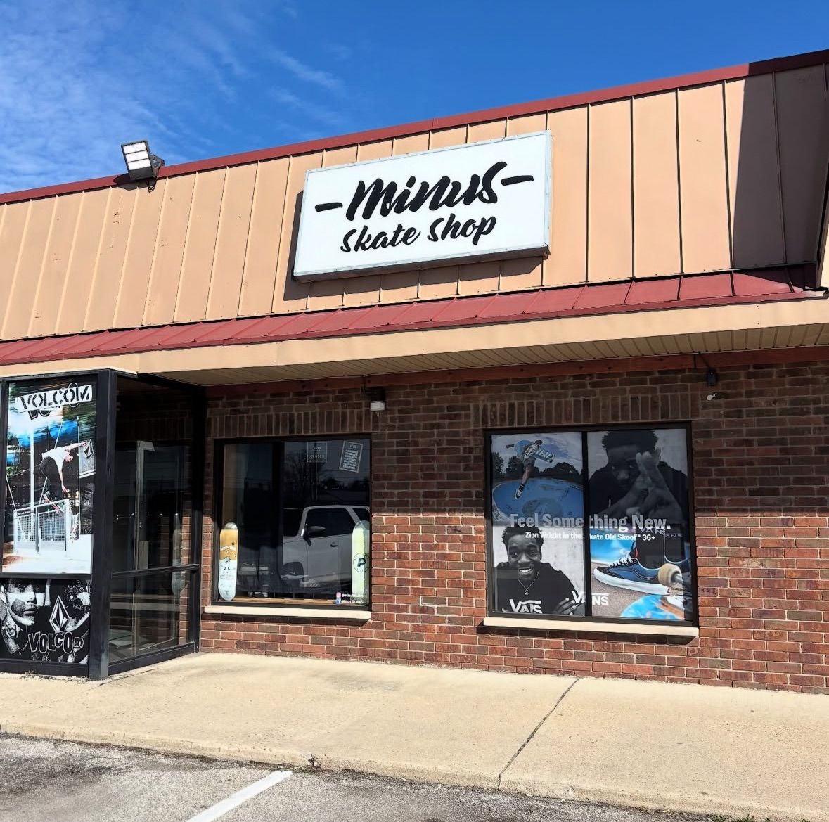 Exterior of Minus Skate Shop storefront with brick facade and large window displays