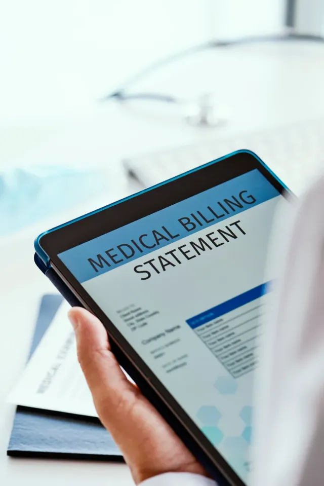 Person holding a tablet displaying a medical billing statement.