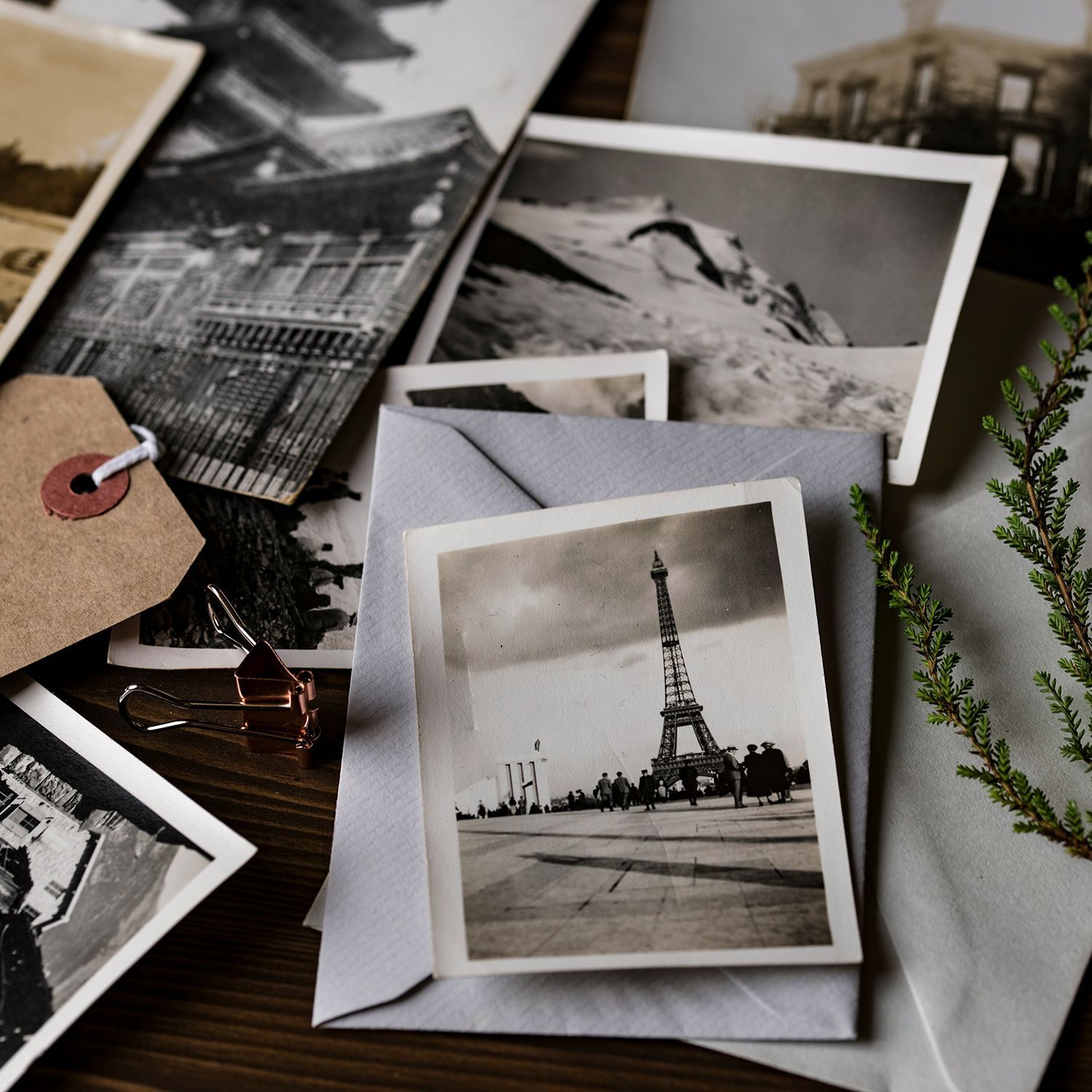 Scattered vintage black-and-white family photos on a tabletop with a sepia tint