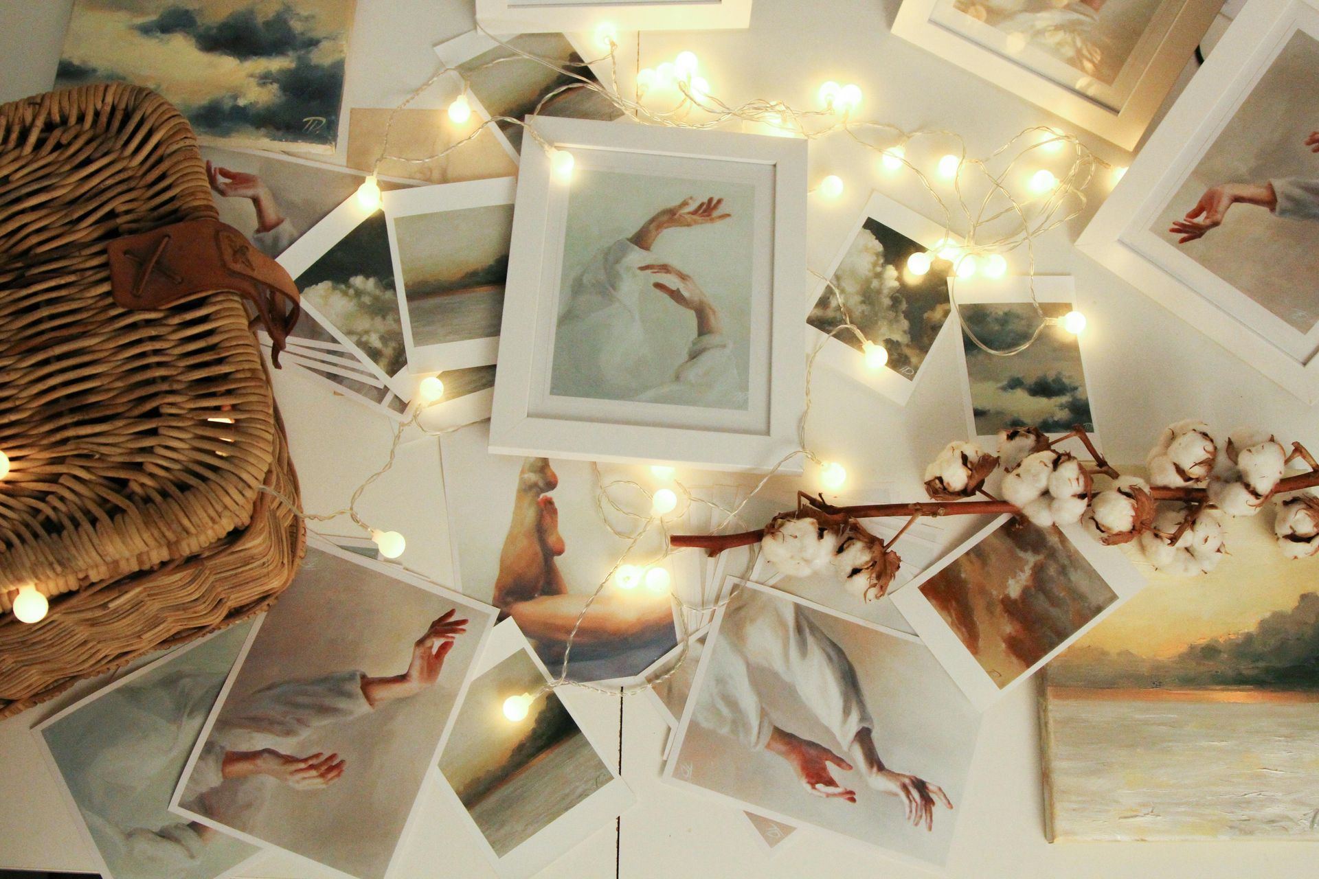 Warm-toned flat lay of bird illustrations, fairy lights, and a wicker basket on a patterned surface