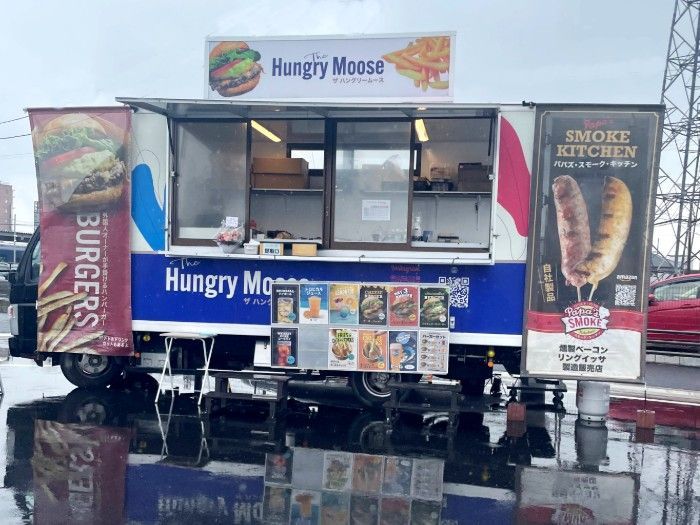 Hungry Moose food truck with blue and white signage, serving window open outdoors on a wet street