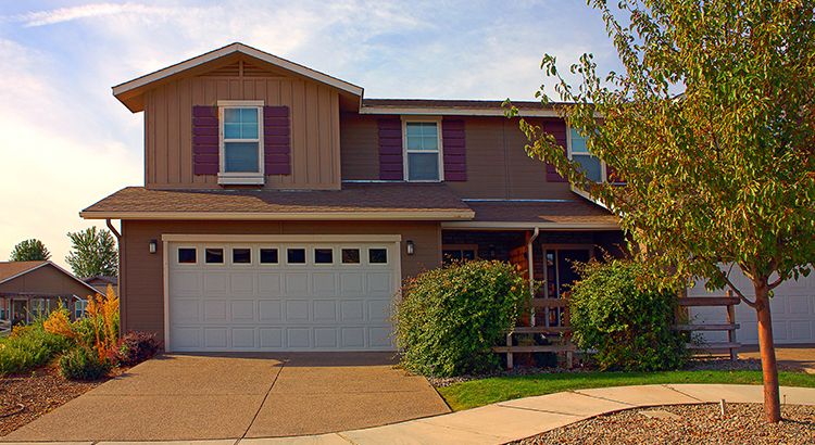 A large brown house with a white garage door
