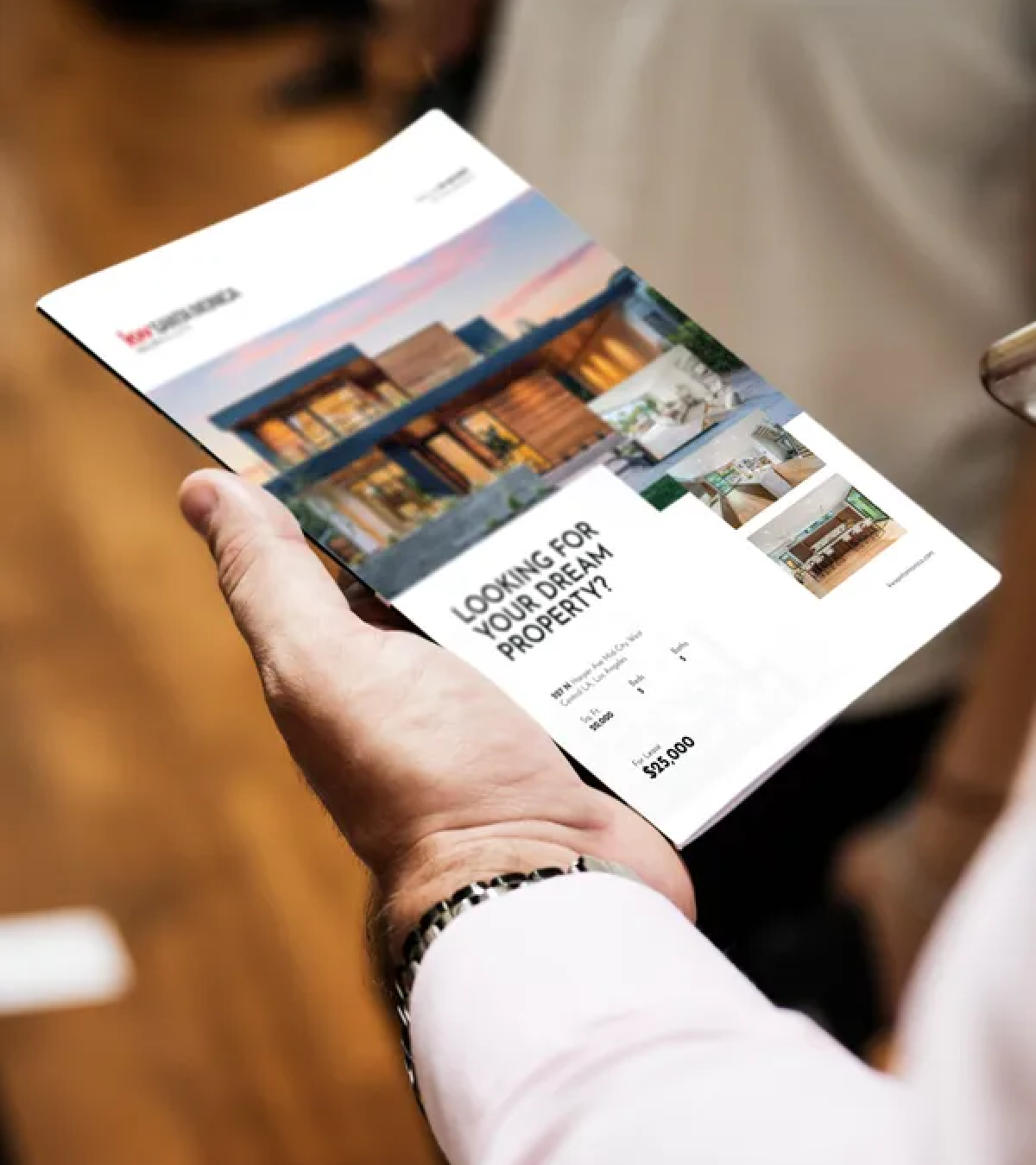 A person is holding a brochure that says looking for your dream property
