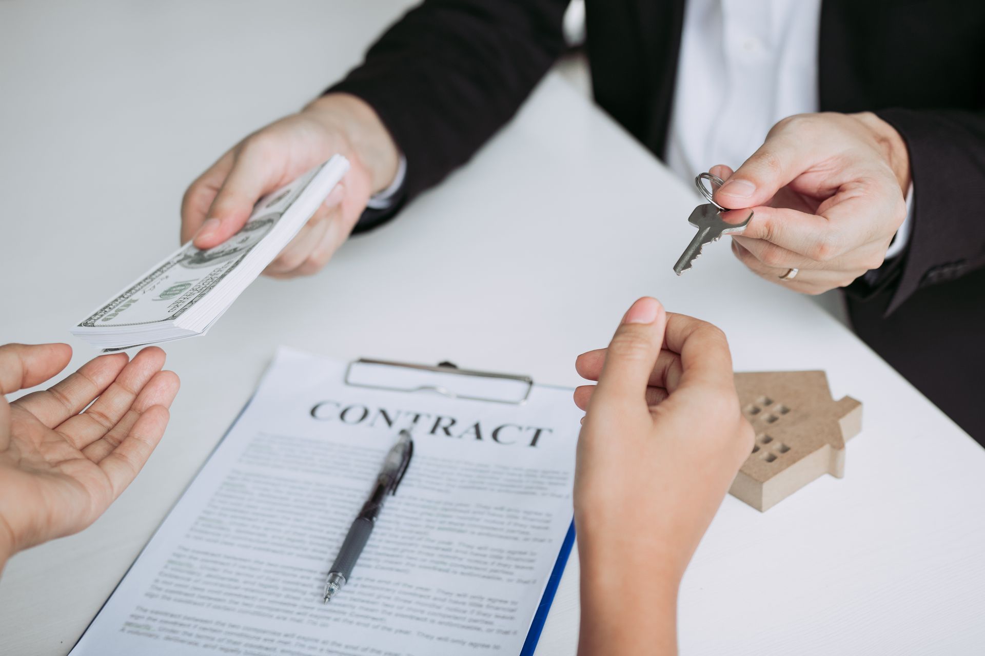 A man is giving a woman a set of keys while sitting at a table.