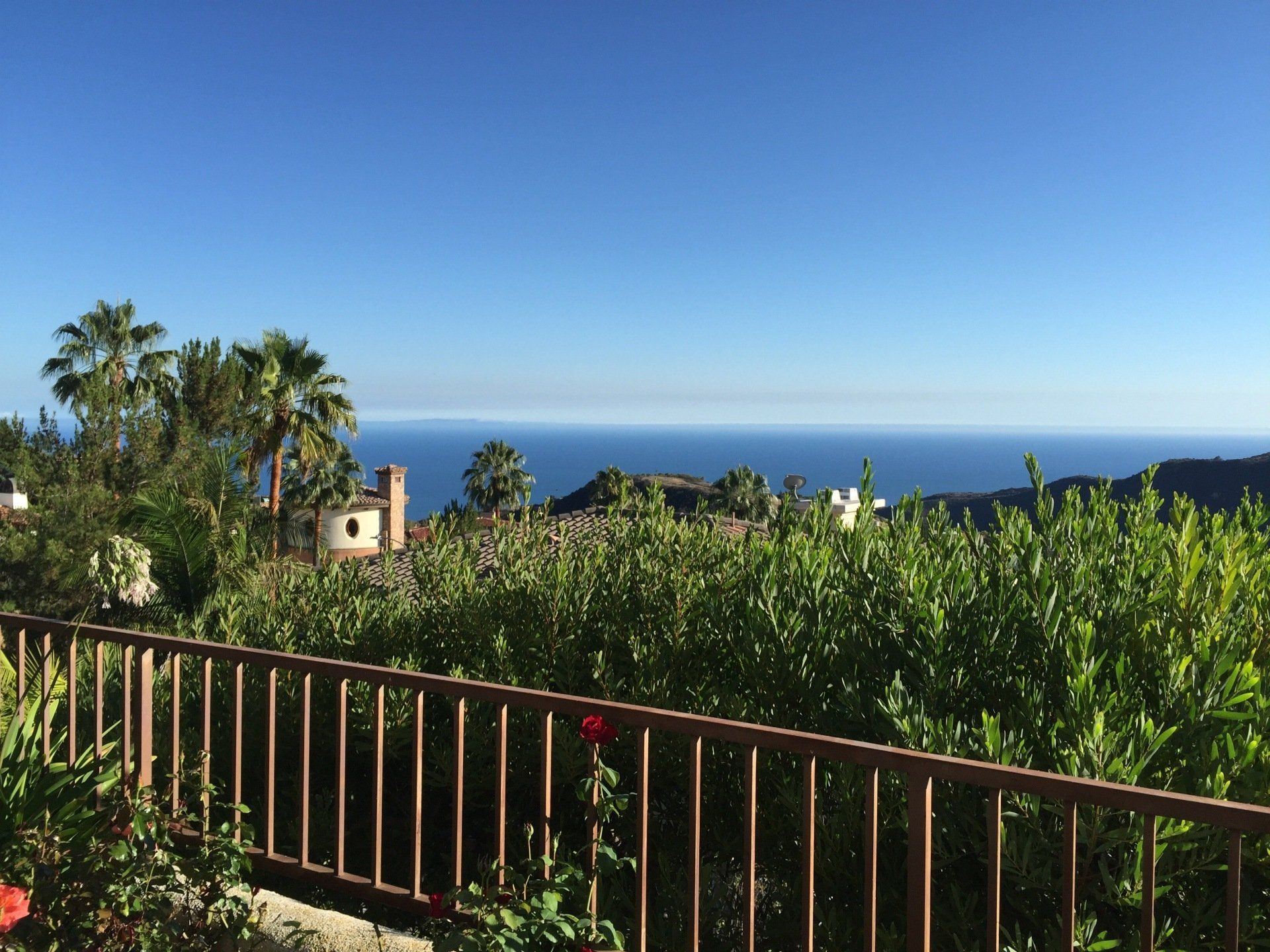 A view of the ocean from a balcony with a fence