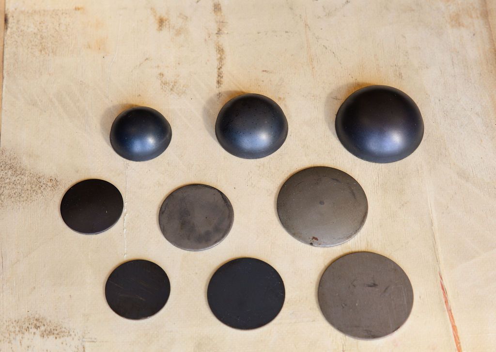 Nine round holes of varying sizes in a beige surface, with dark and gray interiors.