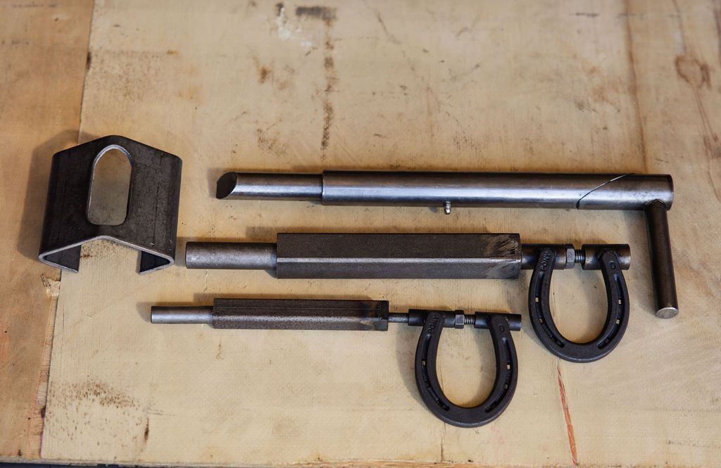 Metal tools and a black block laid on a wooden surface