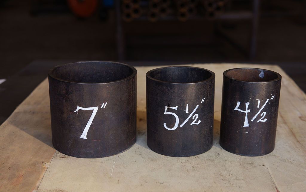 Three black wooden measuring cups labeled 7, 5½, and 4½ on a table.
