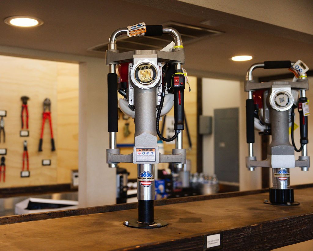 Two silver beer taps on a wooden bar in a brewery interior, with tools hanging on the wall.