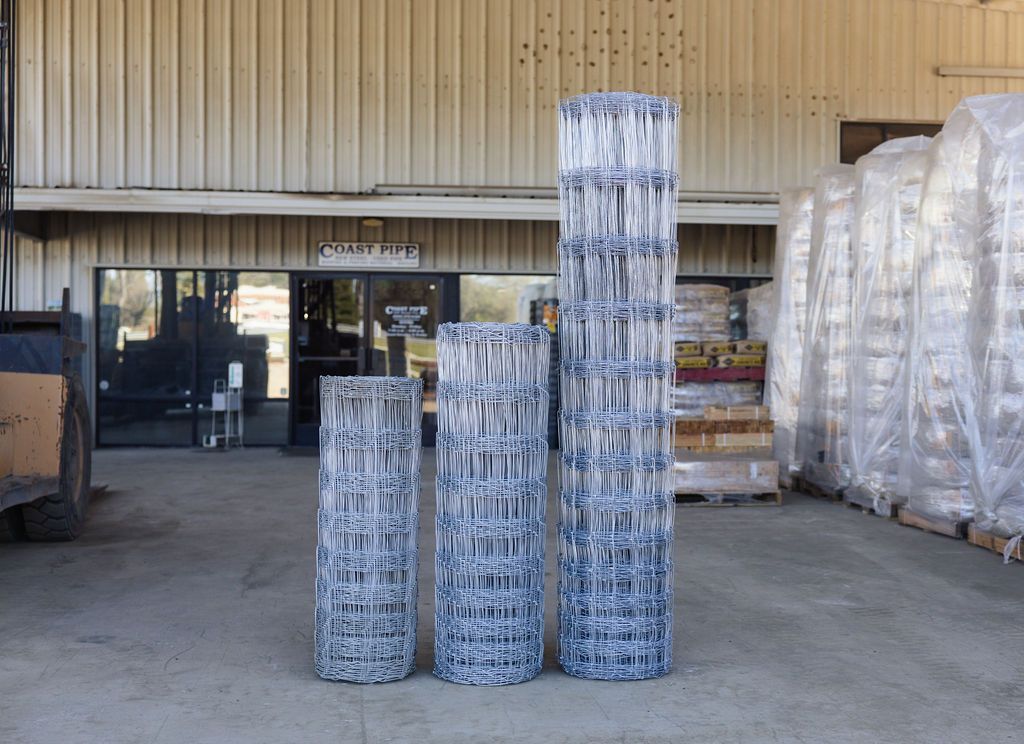 Stacks of shrink-wrapped cans on pallets outside a warehouse loading dock