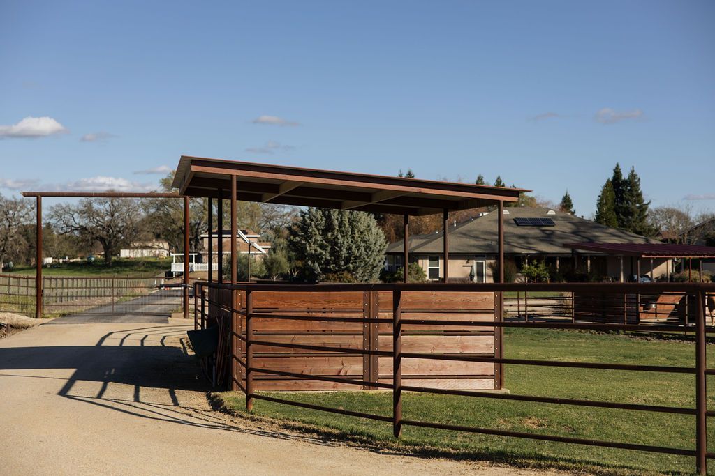 Wooden livestock pens and shelter in a sunny outdoor farm enclosure