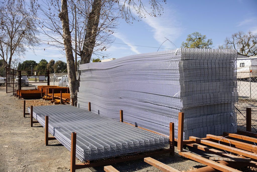Stacks of clear plastic water bottles on pallets outdoors in a parking lot