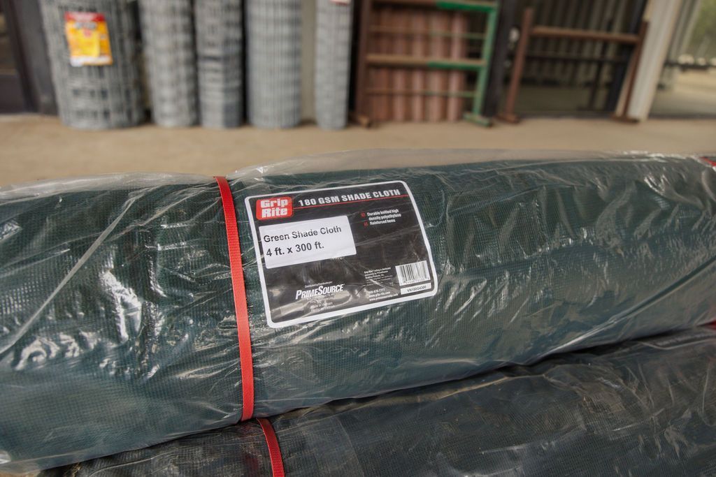 Wrapped dark green package with a red strap and label in a warehouse aisle