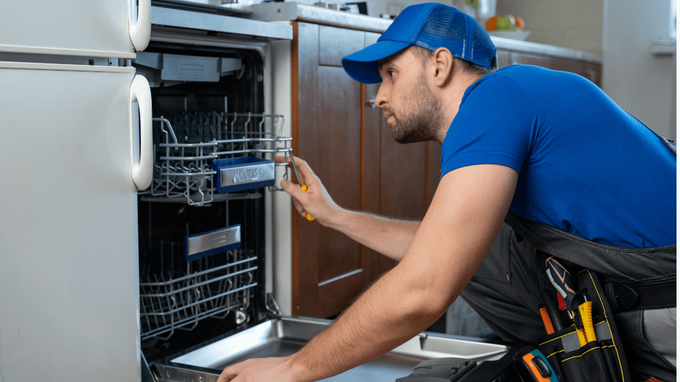 “Technician checking the inside of an open dishwasher in a kitchen during an appliance repair service in Taylorsville, UT”