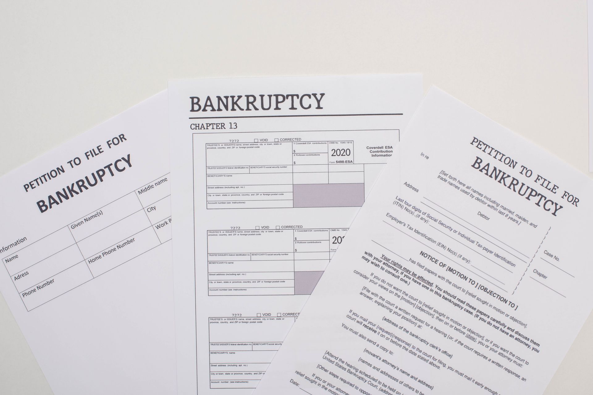 Bankruptcy forms spread on a white table, with one highlighted application in the center
